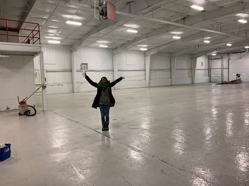 megan standing in empty warehouse interior