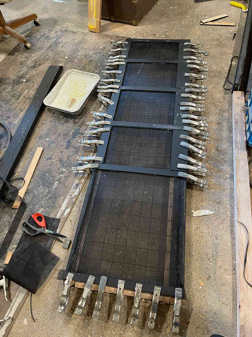 wood frame being clamped down with pet screen