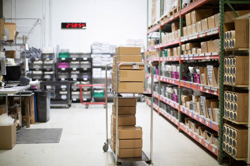 shipping area in the warehouse with a stack of boxes on a cart