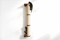 Two small animals climbing a cylindrical cat scratcher on a white background
