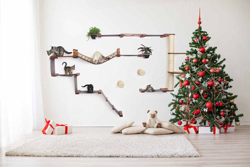 Decorative Christmas tree with red ornaments in a room with cat shelves and toys.