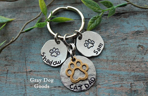 Key chain with paw prints, pets names, and Cat Dad 