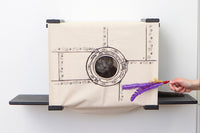 Grey cat looks out of Porthole canvas of Onyx Cubby.