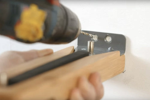 installing a screw through a mounting plank with a power drill