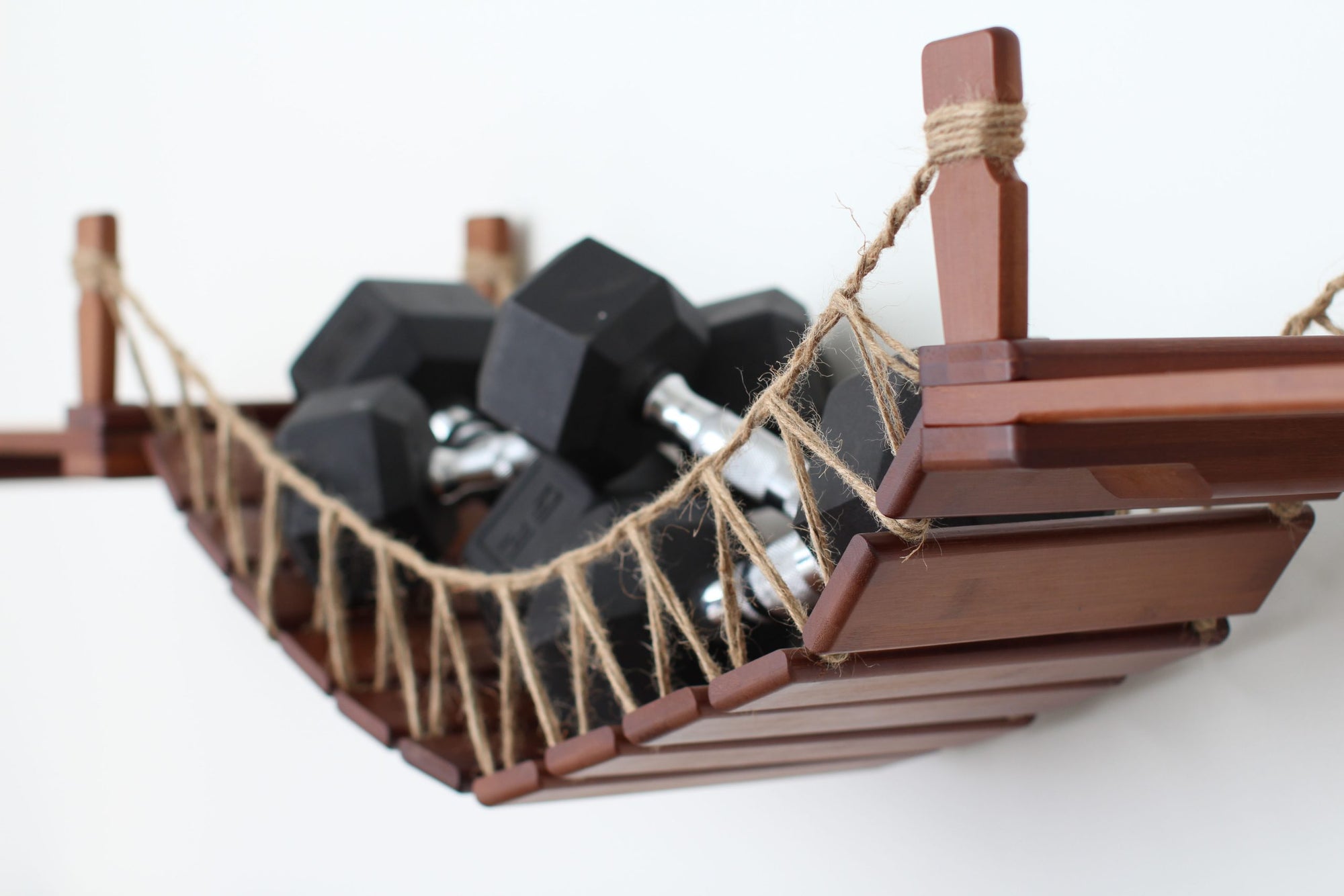 Image of Twine Bridge in English Chestnut finish holding several dumbbells to illustrate weight capacity.